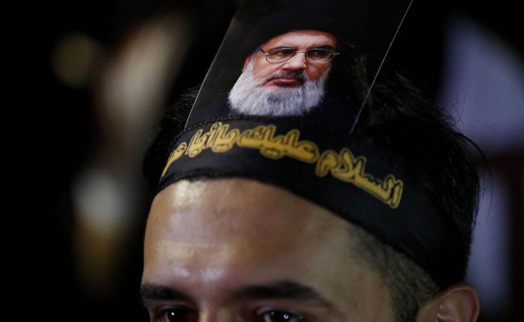 ناشط من حزب الله يرفع صورة لحسن نصرالله على رأسه