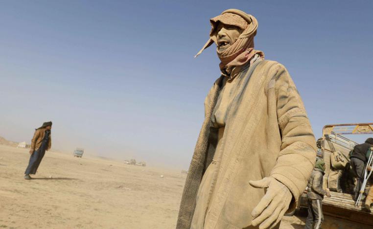 Men queue up in front of an SDF official, who registers each new arrival.