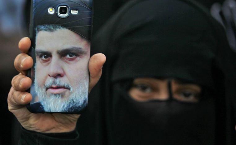 عراقية ترفع صورة مقتدى الصدر في تظاهرة احتجاج على الحكومة وسط بغداد