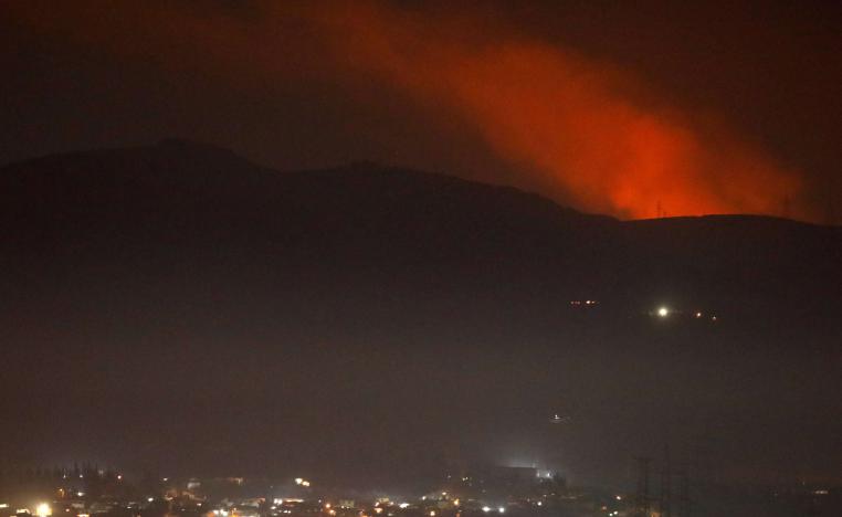 Smoke rises past a mountain as seen from Damascus countryside, Syria December 25, 2018.