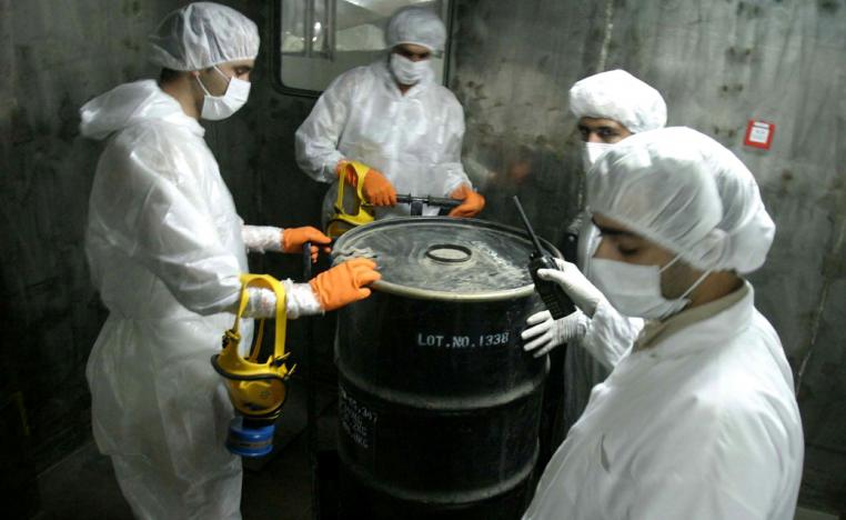 Iranian technicians lift a barrel of "yellow cake" to feed it into the processing line of Uranium Conversion Facility (UCF) in Isfahan, Iran in an August 8, 2005 file photo.
