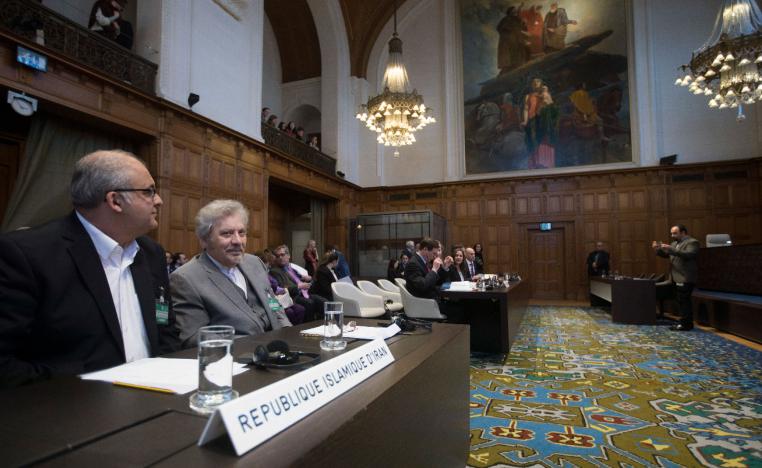 Mohsen Mohebi, agent for the Islamic Republic of Iran, second left, and his delegation take their seats, as the U.S. delegation is seen in the background, right, as they wait for judges to enter the International Court of Justice, or World Court, in The Hague, Netherlands, Wednesday, Feb. 13, 2019.
