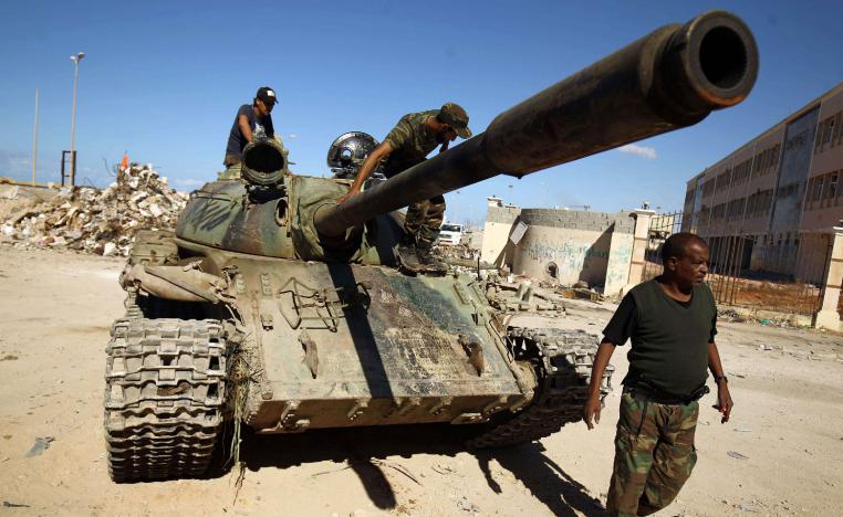 Members of the Libyan National Army ride on a tank.