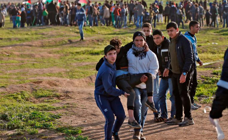 Palestinian demonstrators evacuate a wounded comrade during a demonstration near the fence east of Gaza City, on February 8, 2019.