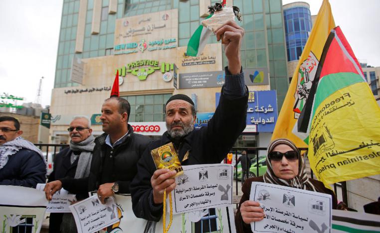 A Palestinian demonstrator holding a copy of Koran takes part in a protest against an Israeli decision to trim funds over prisoner stipends, in Hebron, in the Israeli-occupied West Bank, February 19, 2019.