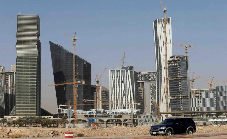 A vehicle drives past the King Abdullah Financial District in Riyadh