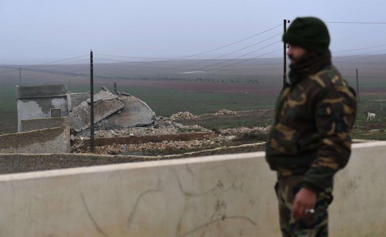 A member of the Syrian regime forces stands on the roof of a building in the southern countryside of the northern Kurdish-controlled city of Manbij on December 30, 2018.