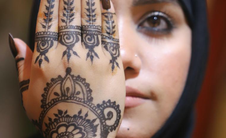 فتاة عراقية تخضب كفها بالحناء في صالون تجميل في البصرة