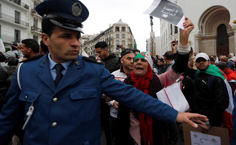 A police officer stands guard as people protest against Algeria's President Abdelaziz Bouteflika, in Algiers, Algeria March 8, 2019.