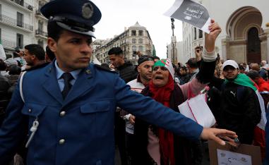 A police officer stands guard as people protest against Algeria's President Abdelaziz Bouteflika, in Algiers, Algeria March 8, 2019.