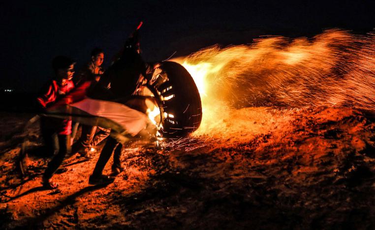 Palestinian protesters take part in a night demonstration near the fence along the border with Israel, in Rafah in the southern Gaza Strip, on March 19, 2019.