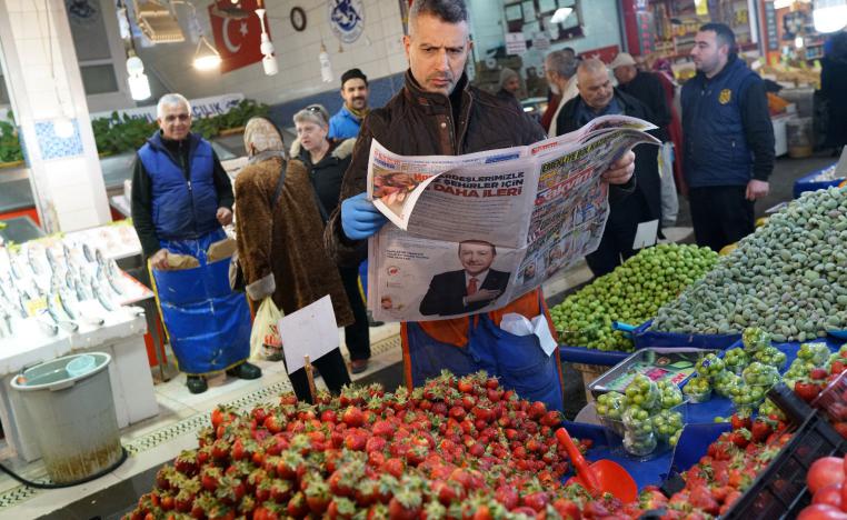A stallholder reads a newspaper as he waits for customers at a bazaar in Ankara, Turkey, March 26, 2019.