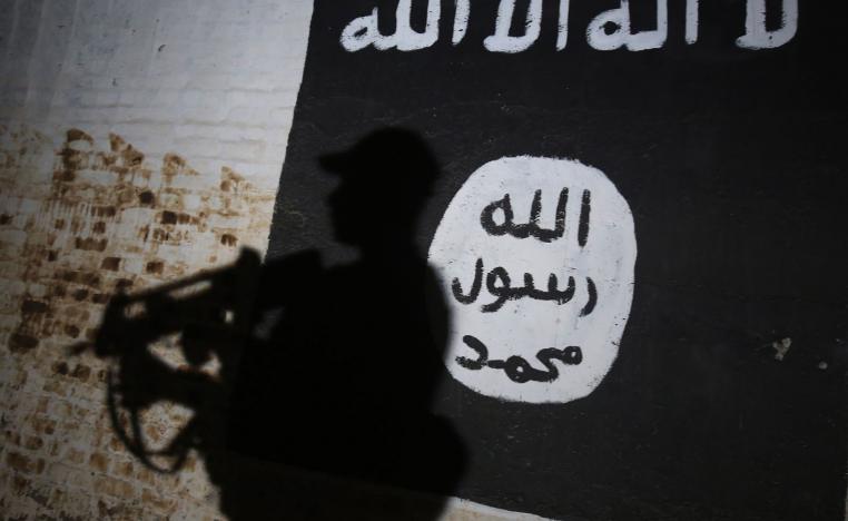 A member of the Iraqi forces walks past a mural bearing the logo of the Islamic State (IS) group in a tunnel that was reportedly used as a training centre by the jihadists in the village of Albu Sayf, on the southern outskirts of Mosul.