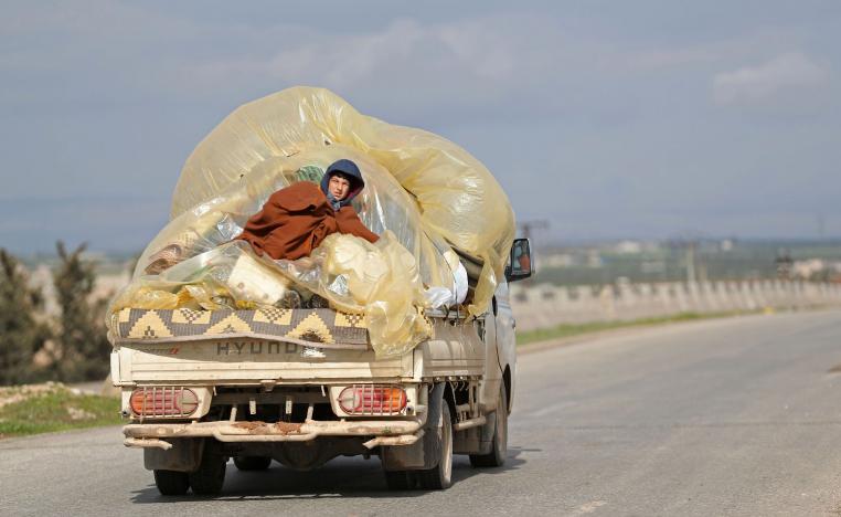 A Syrian man sits at the back of a truck as he leaves from Saraqib on February 27, 2019.