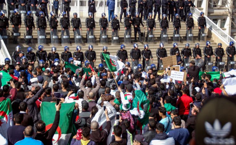 Algerians shout slogans and raise signs and national flags as they protest outside the city hall in the northern coastal city of Oran, about 410 kilometres west of the capital Algiers, on March 1, 2019, during a rally against ailing President Abdelaziz Bouteflika's bid for a fifth term in power.