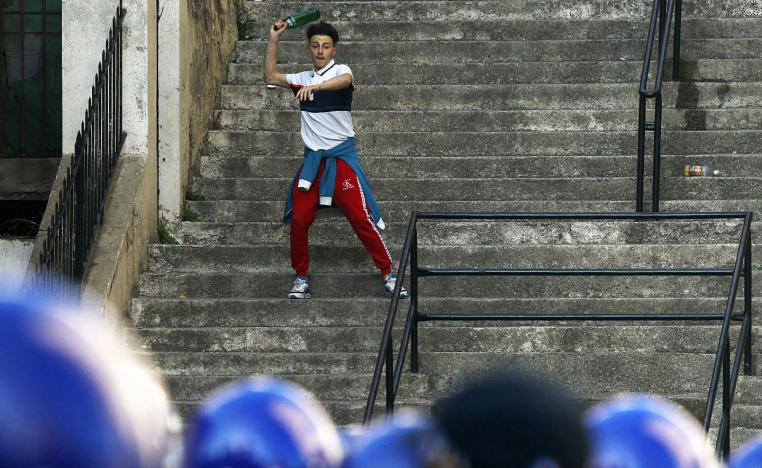 A demonstrator throw a bottle during clashes with police in Algiers, Algeria, March 29, 2019.