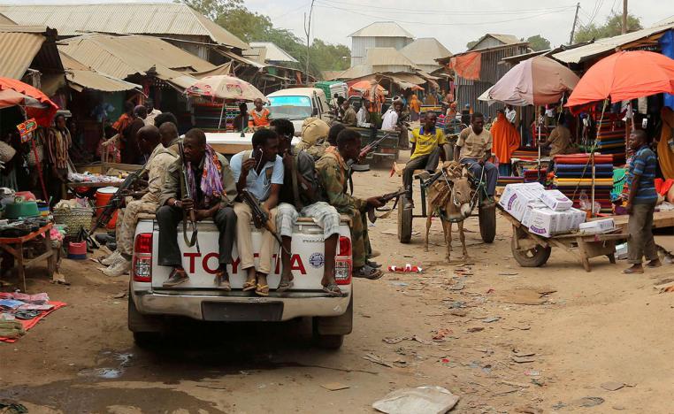 Somali soldiers patrol a street market in Afgoye