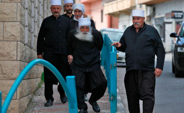 Syrian Druze men walk down a street in the Majdal Shams village in the Israeli-occupied Golan Heights on March 22, 2019.