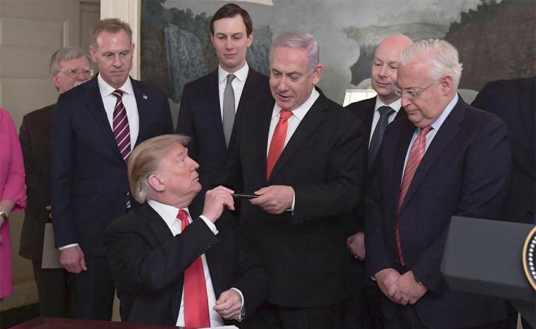 Trump signing a proclamation recognising Israeli sovereignty over occupied Golan Heights