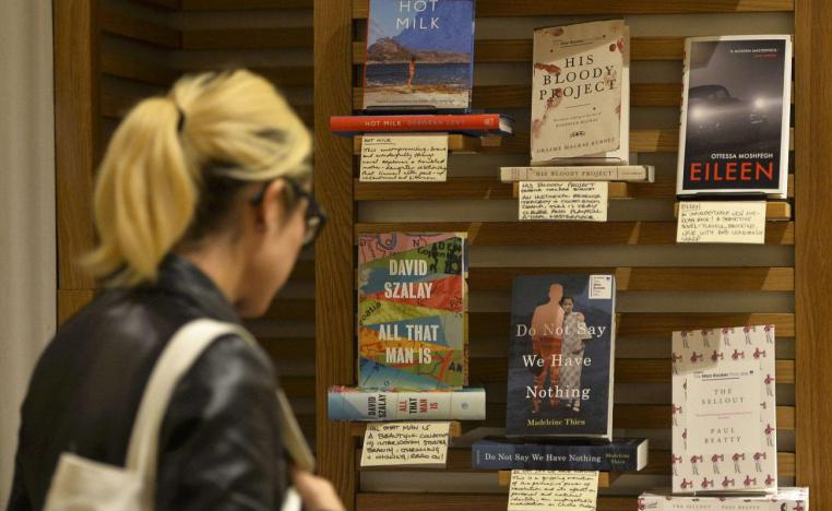 امرأة تنظر إلى قائمة الكتب القصيرة لجائزة مان بوكر في أحد متاجر الكتب بلندن