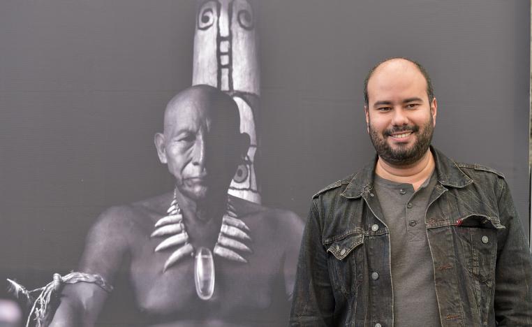 المخرج الكولومبي سيرو غيرا رئيس لجنة تحكيم أفلام أسبوع النقاد يقف بجانب صورة لفيلمه "احتضان الثعبان"