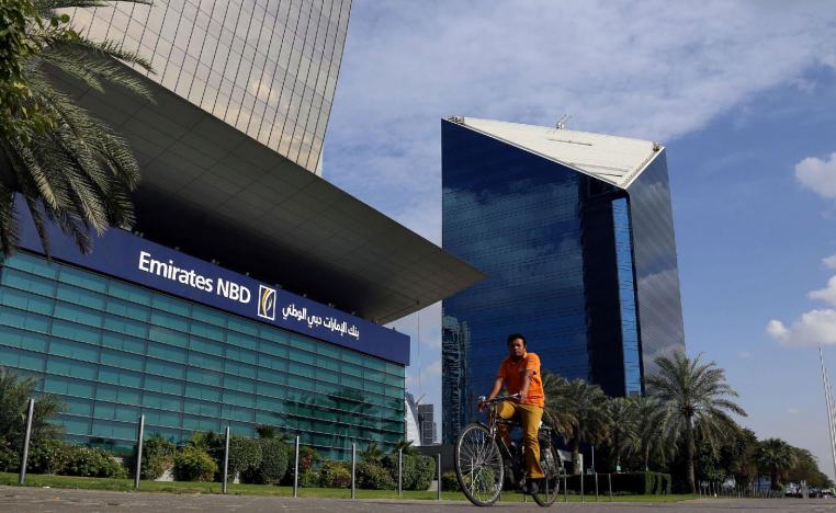 A man rides a bicycle past Emirates NBD head office in Dubai, UAE January 30, 2018.