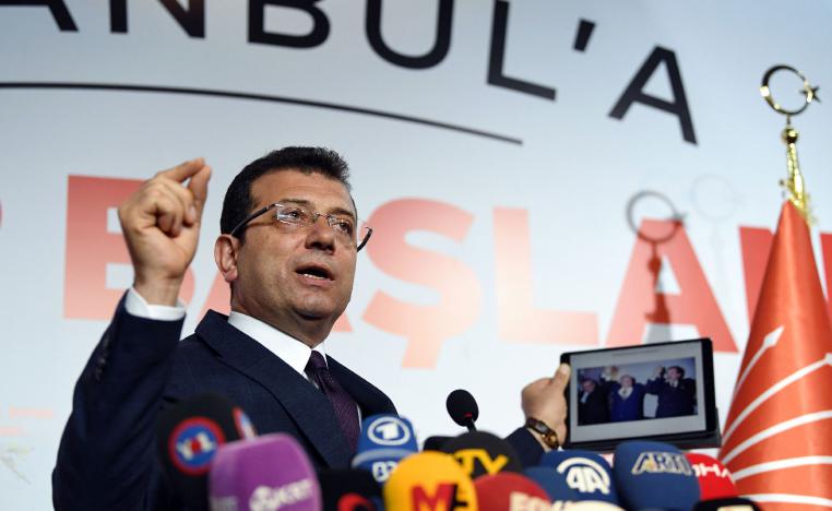 Turkey's main opposition party CHP candidate Ekrem Imamoglu, who claimed victory as Istanbul mayor, shows a picture of the 1994 local election featuring Istanbul Metropolitan municipality Refah Party (RP) candidate Recep Tayyip Erdogan (R), conservative Refah Party (RP) leader Necmettin Erbakan (C) and his opponent Social Democratic Populist Party (SHP) Nurettin Sozen, on his tablet during a press conference at the CHP's Election Coordination Centre in Istanbul on April 3, 2019.