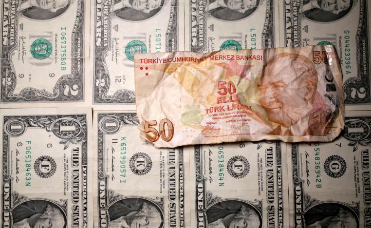 ورقة نقدية تركية على خلفية من الدولارات الأميركية