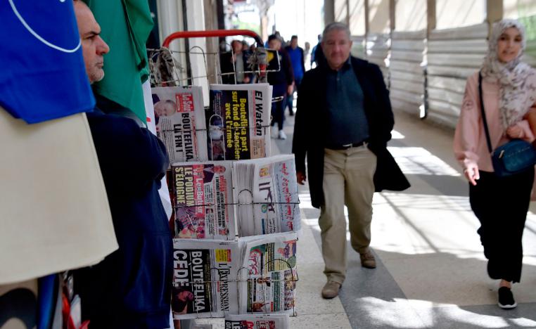Algerians walk past newspapers reading "Bouteflika leaves" the day after Algeria's veteran President Abdelaziz Bouteflika informed the Constitutional Council that he was resigning, in Algiers on April 3, 2019.