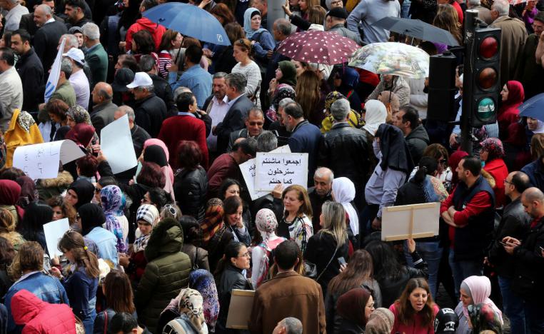Public sector workers hold banners during a protest against any cuts to their salaries in the budget, in downtown Beirut