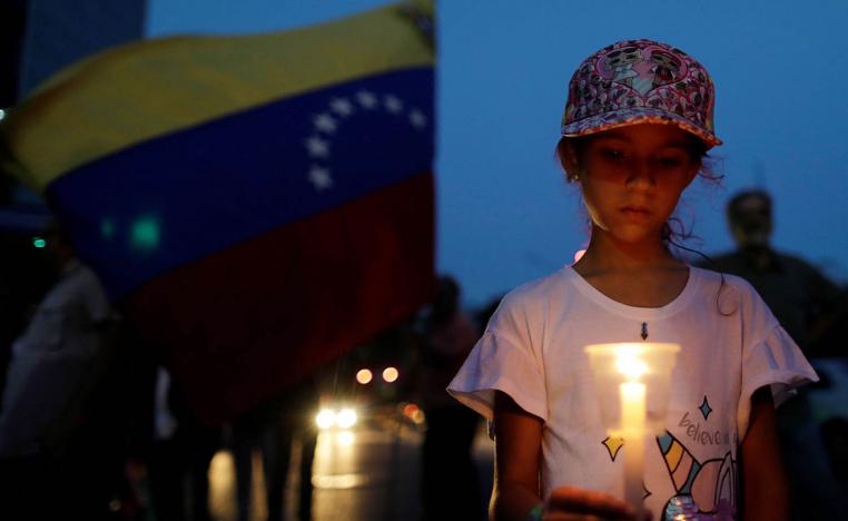 طفلة تحمل شمعة في تظاهرة في كاركاس