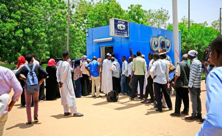 Sudanese people queue up to withdraw money from an ATM in Sudan's capital Khartoum.