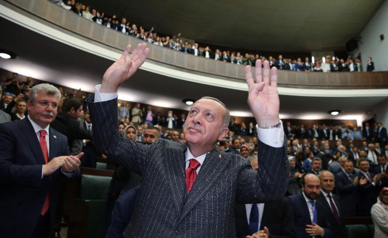 Turkish President Recep Tayyip Erdogan (C) gesturing in front of members of ruling Justice and Development Party (AKP)