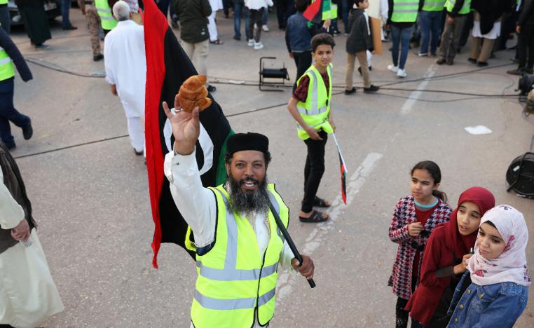A Libyan protester holds a croissant as he attends a demonstration in Tripoli