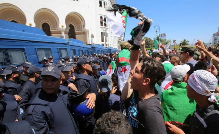 A demonstrator chants slogans in front of police during an anti-government protest in Algiers
