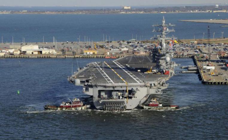 2013 file picture shows tug boats assisting the Nimitz-class aircraft carrier USS Dwight D. Eisenhower (CVN 69) as it pulls away from the pier at Naval Station Norfolk, Virginia