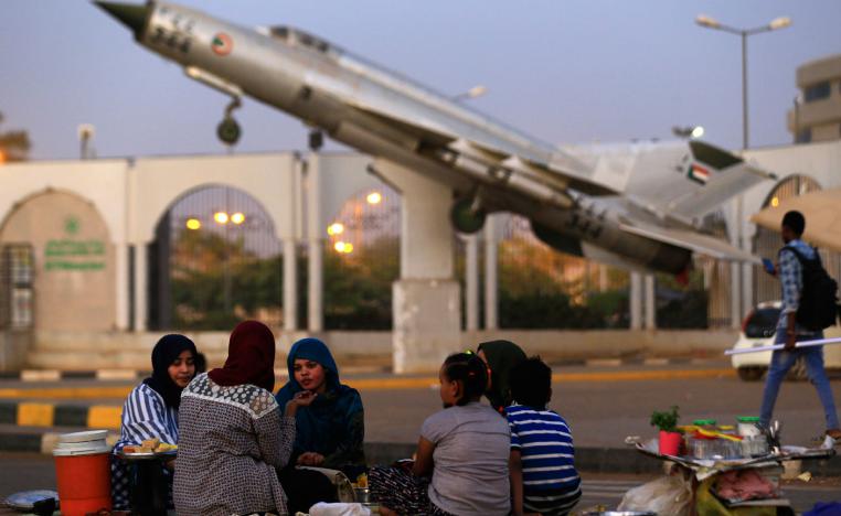 Sudanese protesters share an Iftar meal as they continue to gather outside the military headquarters in the capital Khartoum