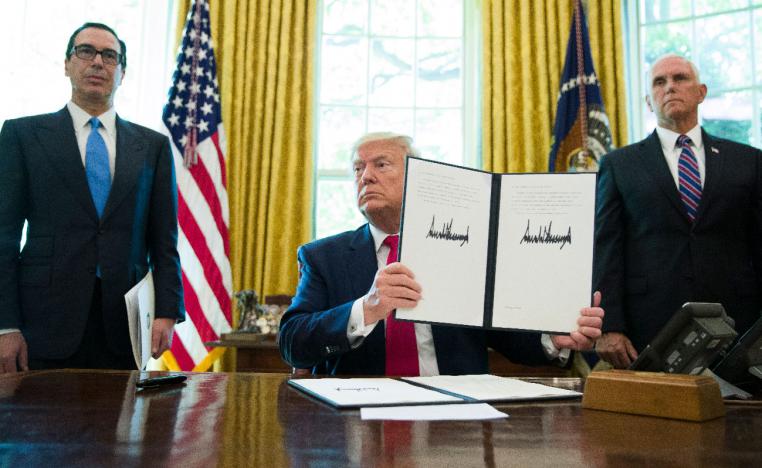President Donald Trump holds up a signed executive order to increase sanctions on Iran