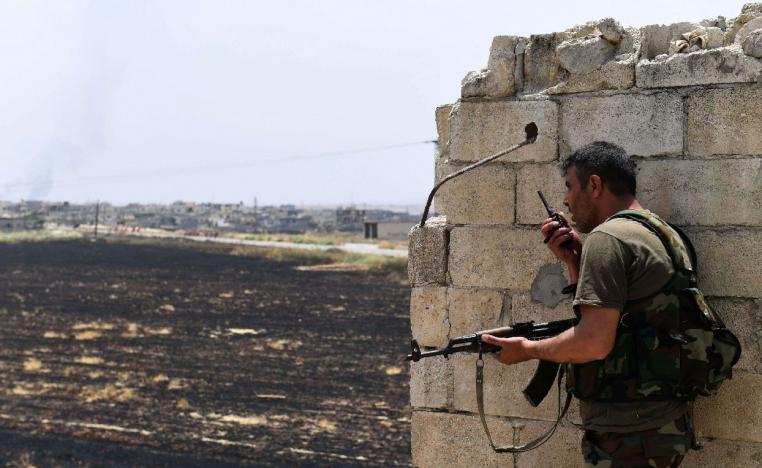 A fighter with the Syrian regime forces holds a position in Syria's Hama province