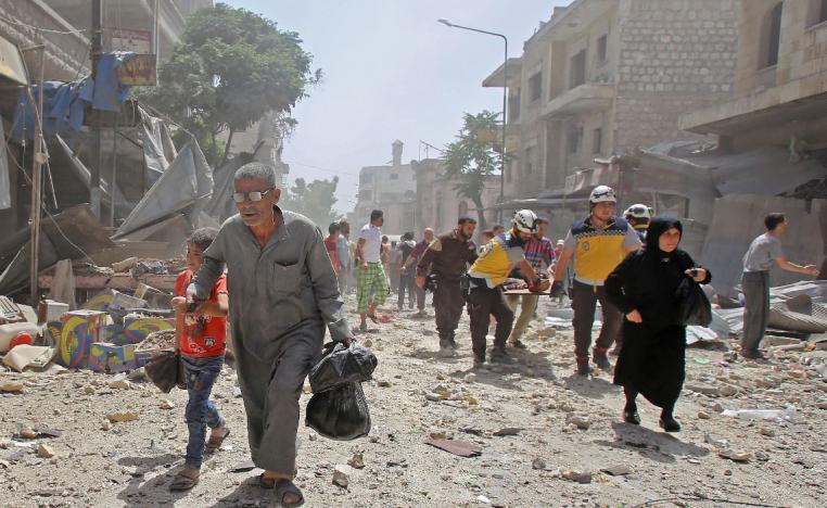 Syrians flee following an air strike on the town of Maaret al-Numan in Idlib province