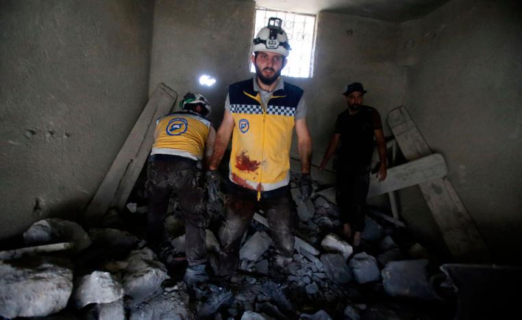 Members of the Syrian Civil Defence dig through the rubble of a building following reported airstrikes