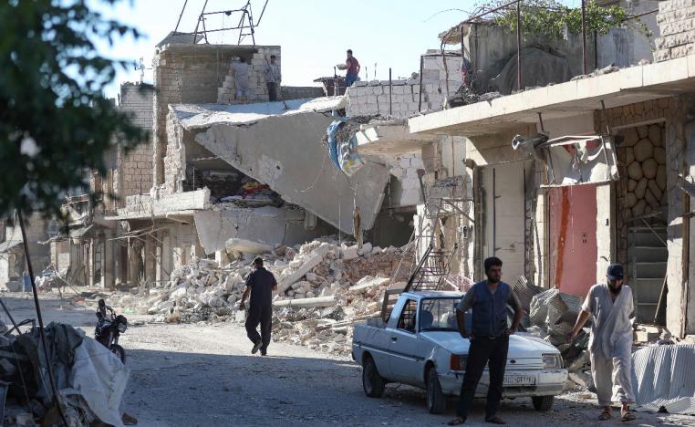 Residents of the village of Kafr Nabl check the damage caused by a pro-regime air strike
