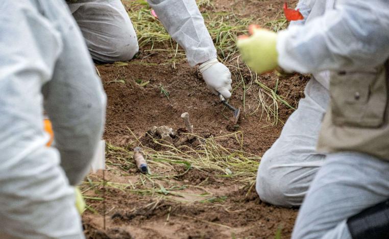 Forensic workers inspect a zone during the exhumation of a mass-grave of hundreds of Yazidis killed by Islamic State (IS) group militants in the northern Iraqi village of Kojo