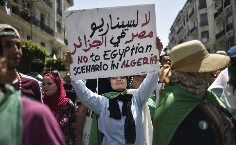 An Algerian woman raises a placard as she takes part in a weekly demonstration in the capital Algiers