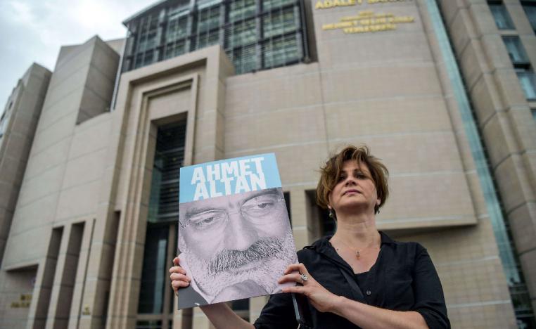Journalist posing with a portrait of Turkish journalist Ahmet Altan in front of the Istanbul courthouse