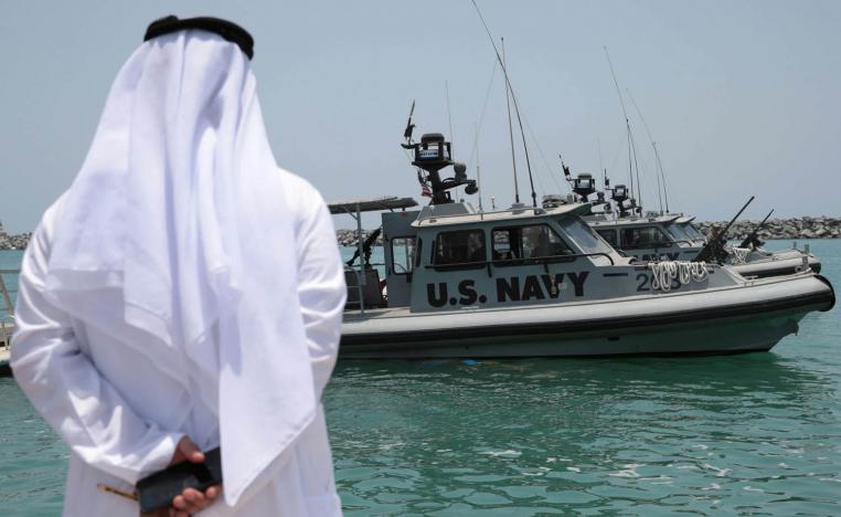 إماراتي ينظر إلى طرادات حربية أميركية في ميناء الفجيرة