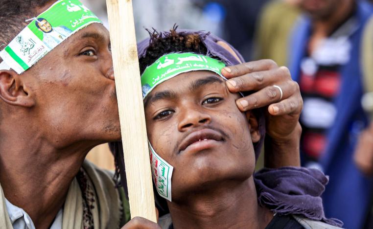 A supporter of Yemen's Huthi rebels kisses the forehead of another during a demonstration in the Huthi-held capital Sanaa