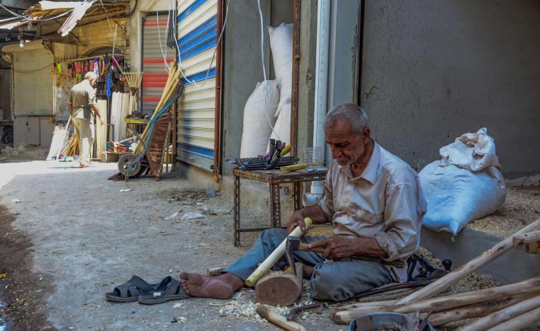 عراقي يعد معاول للبناء في سوق الموصل