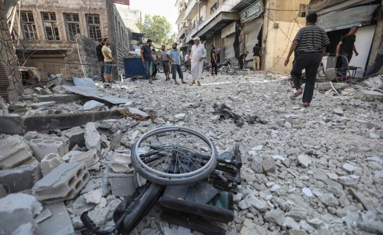 A wheelchair is seen amid the rubble of destroyed buildings following a reported regime air strike on the town of Ariha