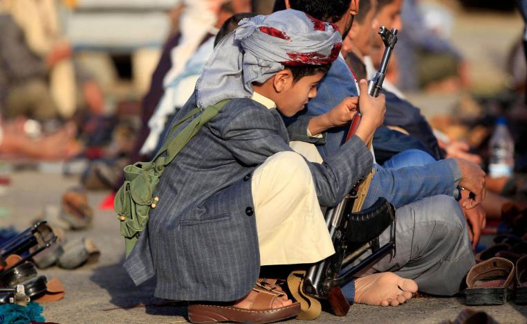 طفل يحمل سلاحا خلال الصلاة في مسجد في صنعاء